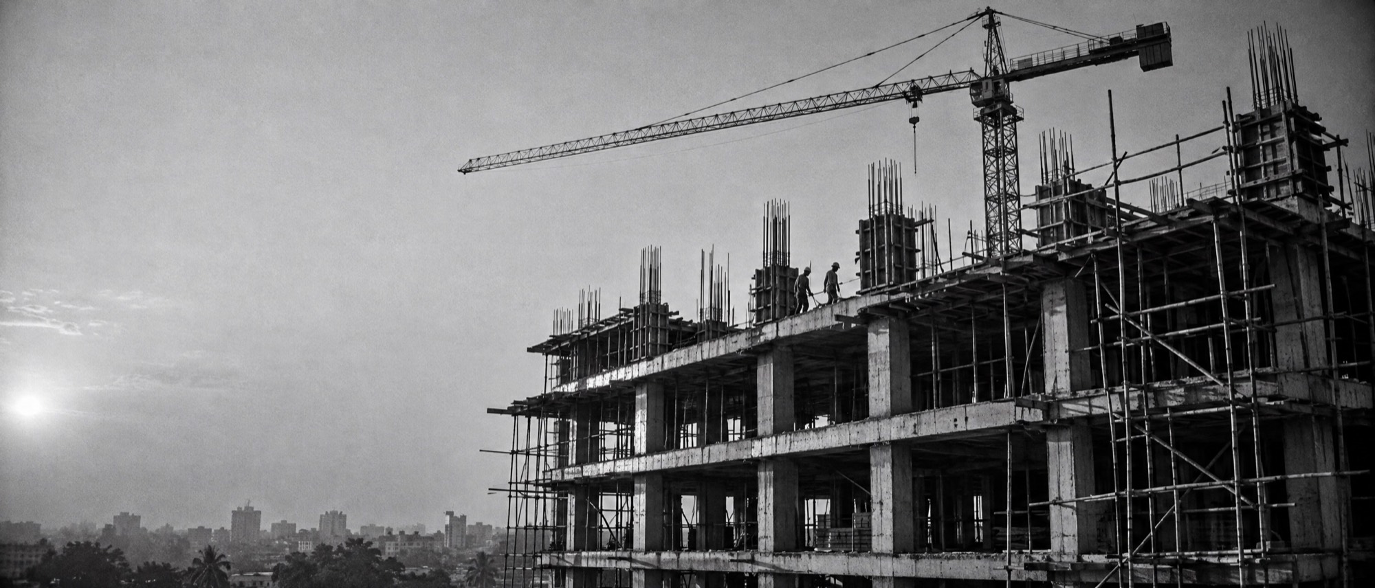 Reinforced concrete building frame under construction, late afternoon light